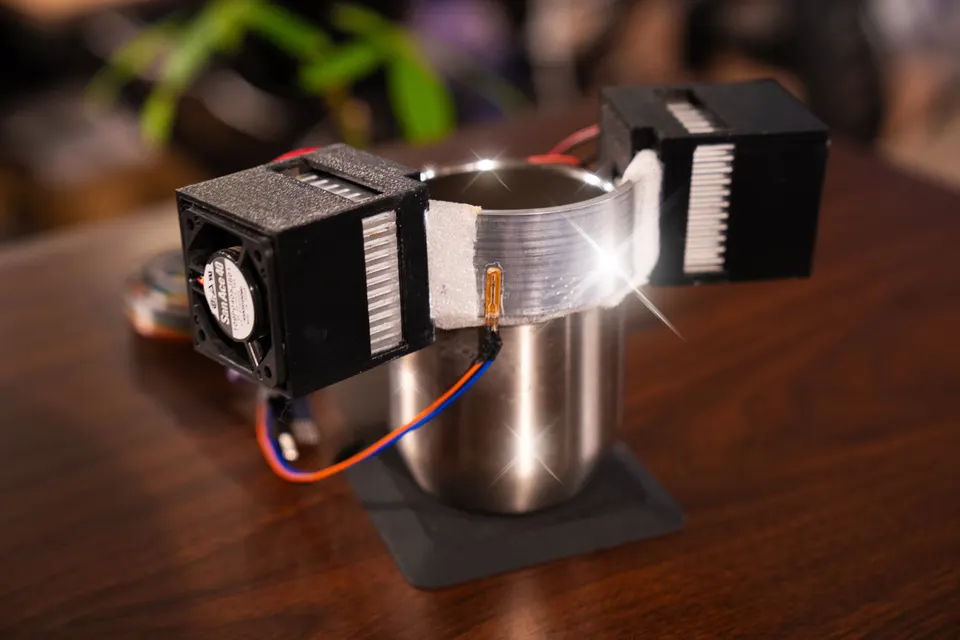 A prototype of the TSU→GI CUP 'TEMP' vessel: a metal cup with fan-cooled heat sinks and a temperature sensor attached around its rim